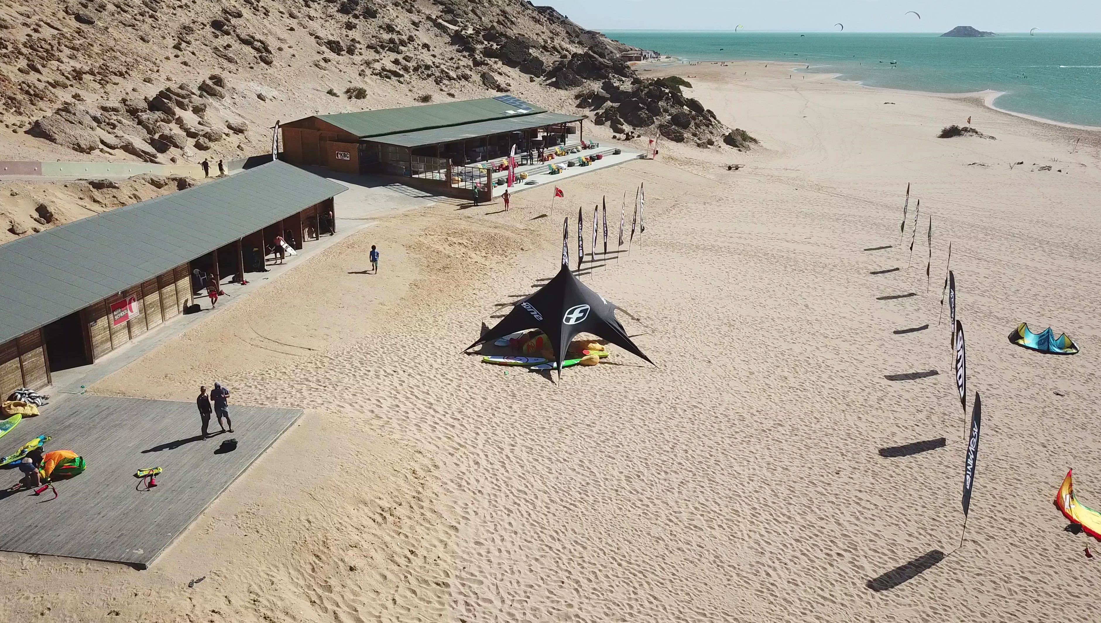 A beach with a building labeled 'KBC' and a tent-like structure in the center.
