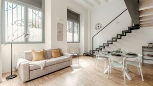 A modern living room with a sofa, coffee table, and dining table set. - Porta Torre Lofts (Como)