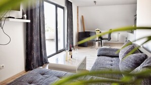 A modern living room with a sofa, a coffee table, and a TV. - Haff-Ostseeferienhaus (Monkebude)