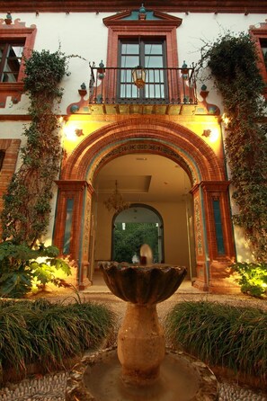 A grand entrance with an ornate archway, a large decorative fountain, and lush greenery. - Hotel Museo Patria Chica (Priego de Córdoba)