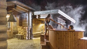 Una baita in legno con idromassaggio e camino.