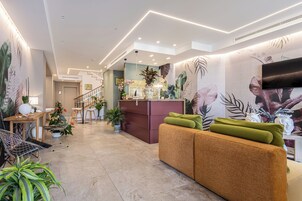 Un interior moderno con un mostrador de recepción, zona de estar y una escalera.
