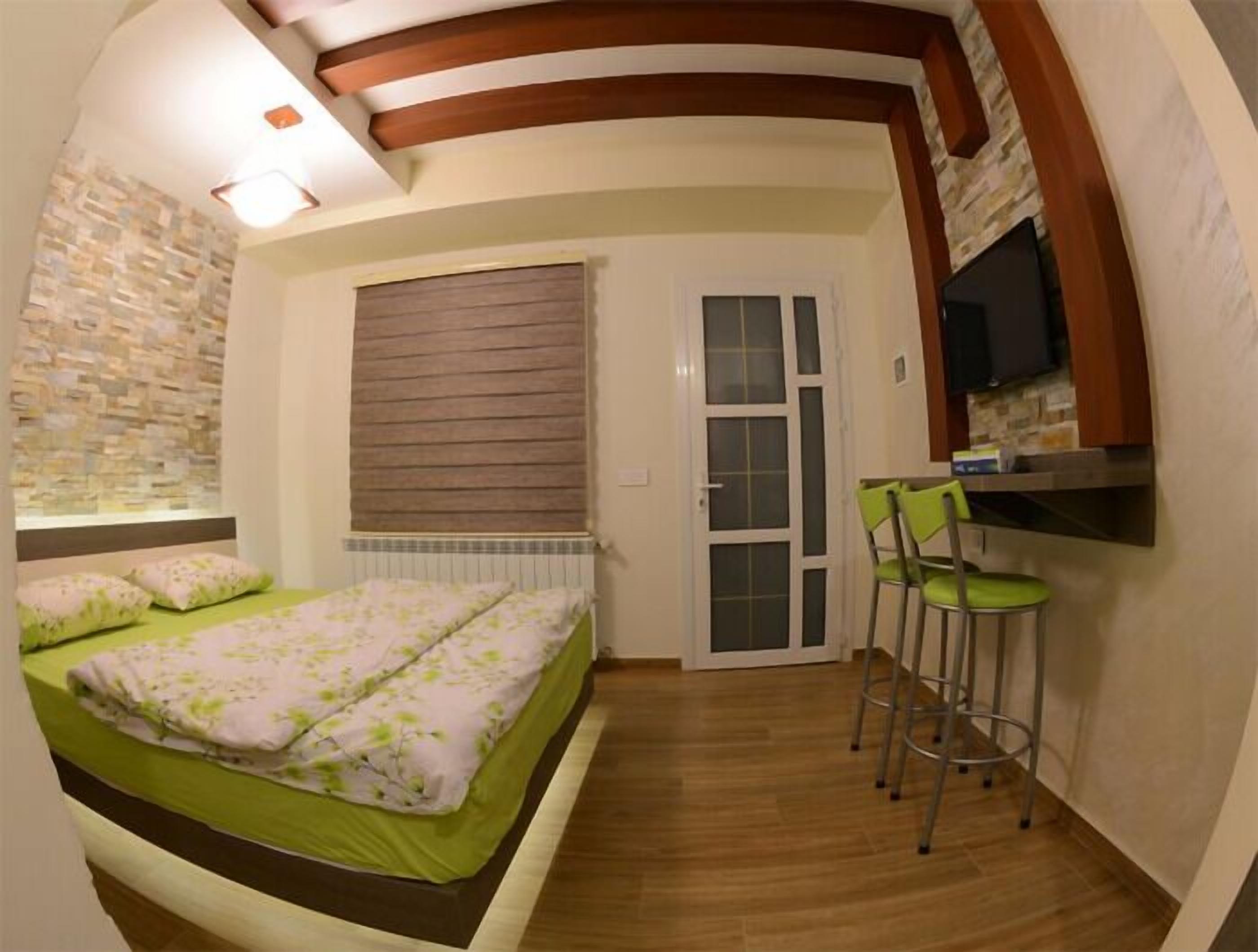 Una habitación pequeña con cama, un kitchenette y una ventana.