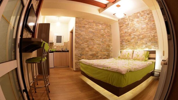 Habitación compacta con cama, una kitchenette pequeña y baño.