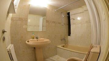 A bathroom with a sink, toilet, and bathtub.