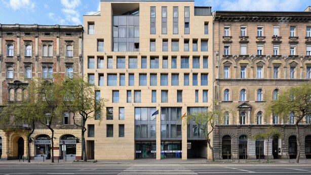 Un bâtiment moderne doté d’une entrée centrale, de grandes fenêtres et d’une façade plane.