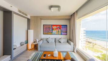 Una habitación de hotel moderna con un sofá, una mesa de centro y un cuadro.