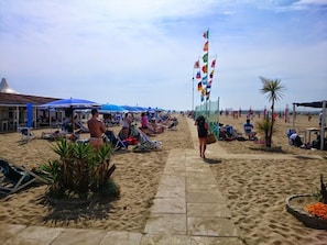 A beach with sun loungers, umbrellas, and a pathway. - Hotel Andrea Doria (Viareggio)