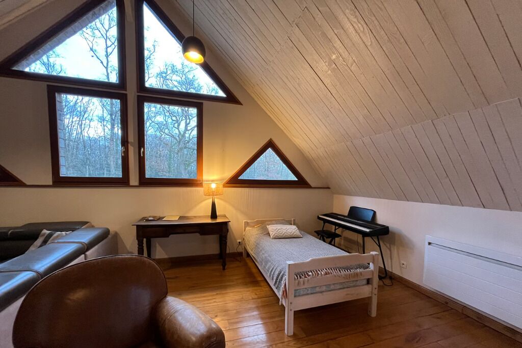 Une chambre avec un plafond de style industriel, un lit, un bureau, une chaise et un piano.