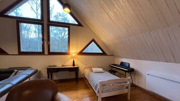 Une chambre avec un plafond de style industriel, un lit, un bureau, une chaise et un piano.
