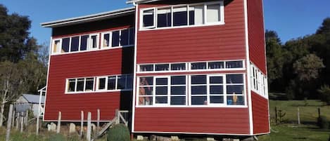 A two-story red building with white trim and multiple windows.