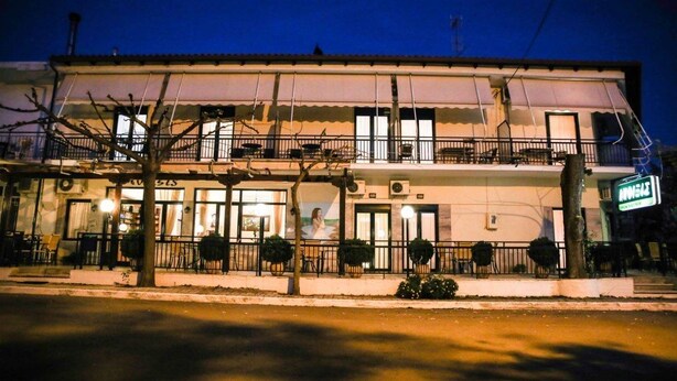 Un bâtiment à deux étages doté d’un balcon et d’un espace extérieur aménagé pour s’asseoir.