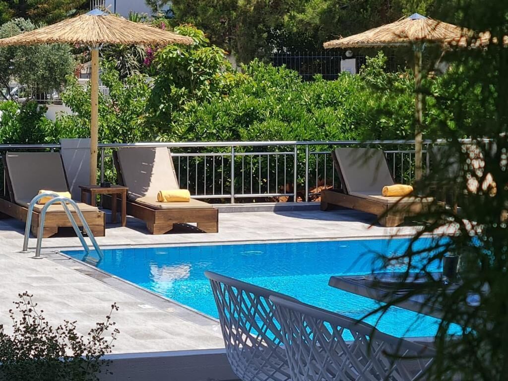 A pool area with lounge chairs and umbrellas.