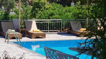 A pool area with lounge chairs and umbrellas.
