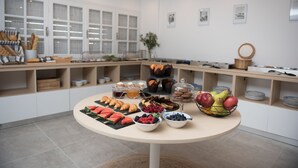Un bufé de desayuno con diversos pasteles, frutas y bebidas.