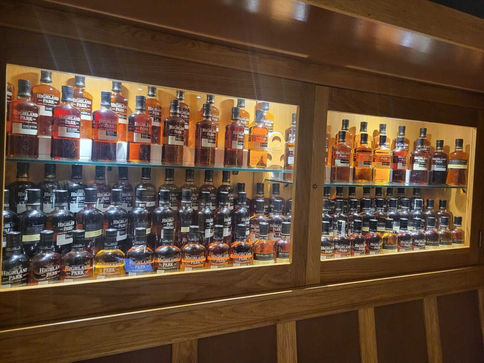 Una vetrina con bottiglie di whisky Highland Park in un armadio di legno.