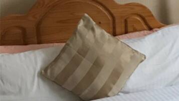Una cama con cabecera de madera y almohada a rayas.