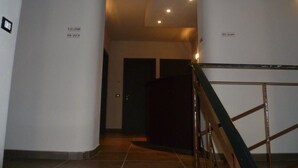Ein Korridor mit Treppe, Zimmernummern an den Wänden und einer Tür am Ende.
