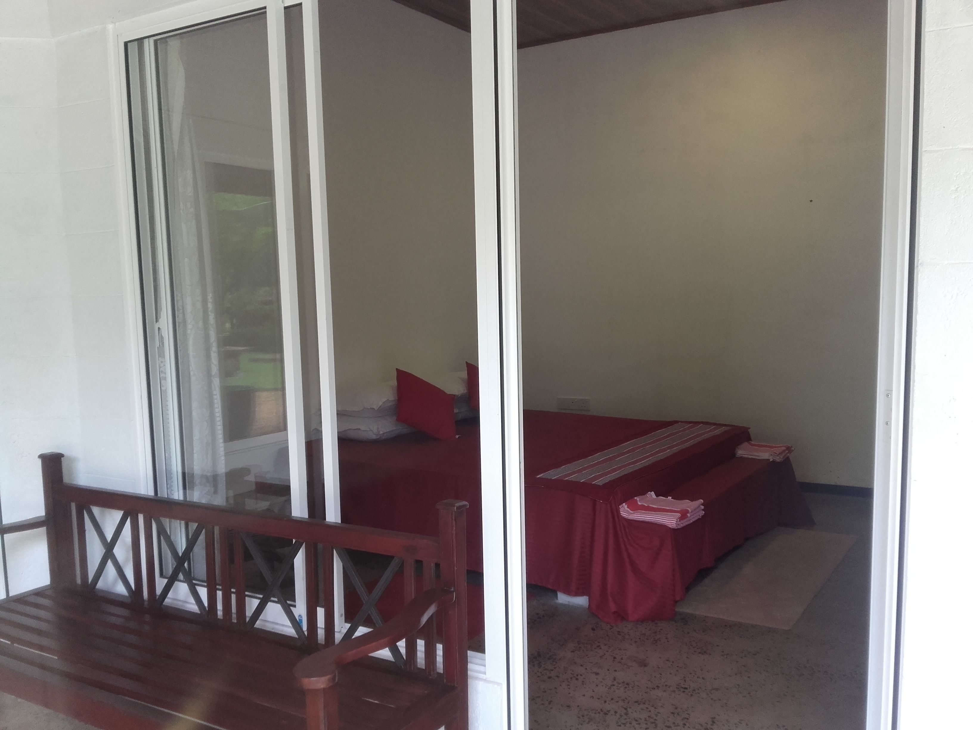 A room with a bed, a small table, and a wooden bench.