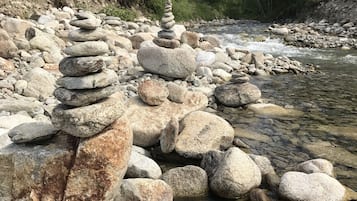 A rocky riverbank with stacked stones and clear water.
