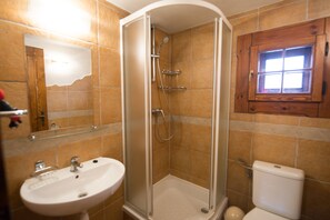 A bathroom with a glass-enclosed shower, a sink, and a toilet. - Drevenice TriMount (Bobrovec)
