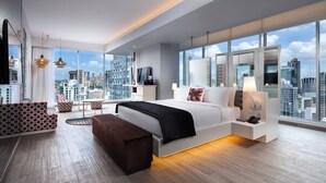 A modern hotel room with a large bed, a desk, a chair, and a view of the cityscape. - W Panama (Panama City)