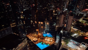 A high-rise building with a rooftop pool area, surrounded by other buildings. - W Panama (Panama City)