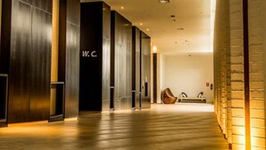 Un pasillo con piso de madera, una recepción y un letrero que dice "W.C.".