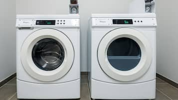 Two front-loading Whirlpool washing machines side by side in a laundry room with tiled flooring.