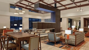 A spacious lobby with a high ceiling, modern furniture, and a central seating area. - Embassy Suites by Hilton South Jordan Salt Lake City (South Jordan)