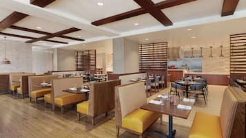 Un ristorante moderno con travi in legno, cabine e una sala da pranzo centrale.