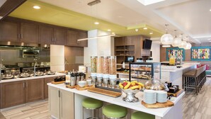 Une cuisine moderne dotée d’un îlot central, de tabourets de bar et d’un comptoir pour prendre le petit-déjeuner.