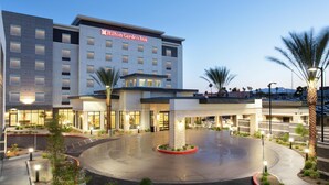 Un hôtel moderne doté d’une grande entrée, d’une cour bien éclairée et d’une enseigne bien visible indiquant « Hilton Garden Inn ».