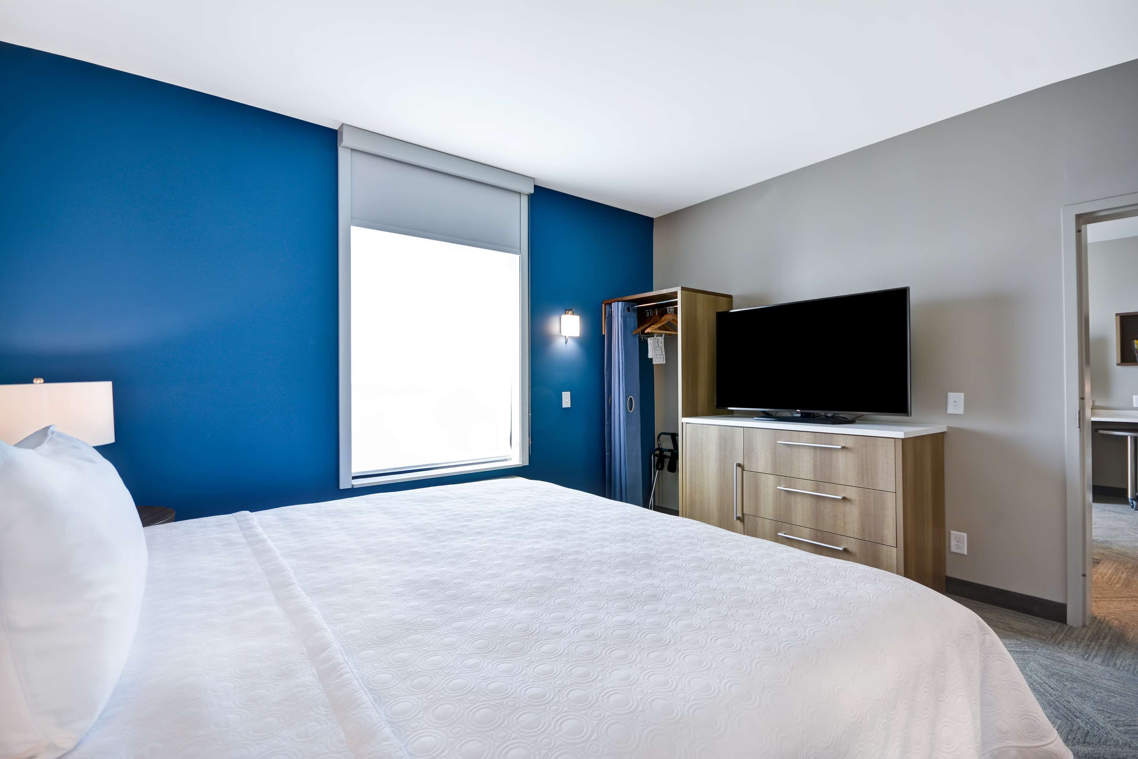 Habitación de hotel con una cama grande, televisión de pantalla plana, armario y ventana con vistas.