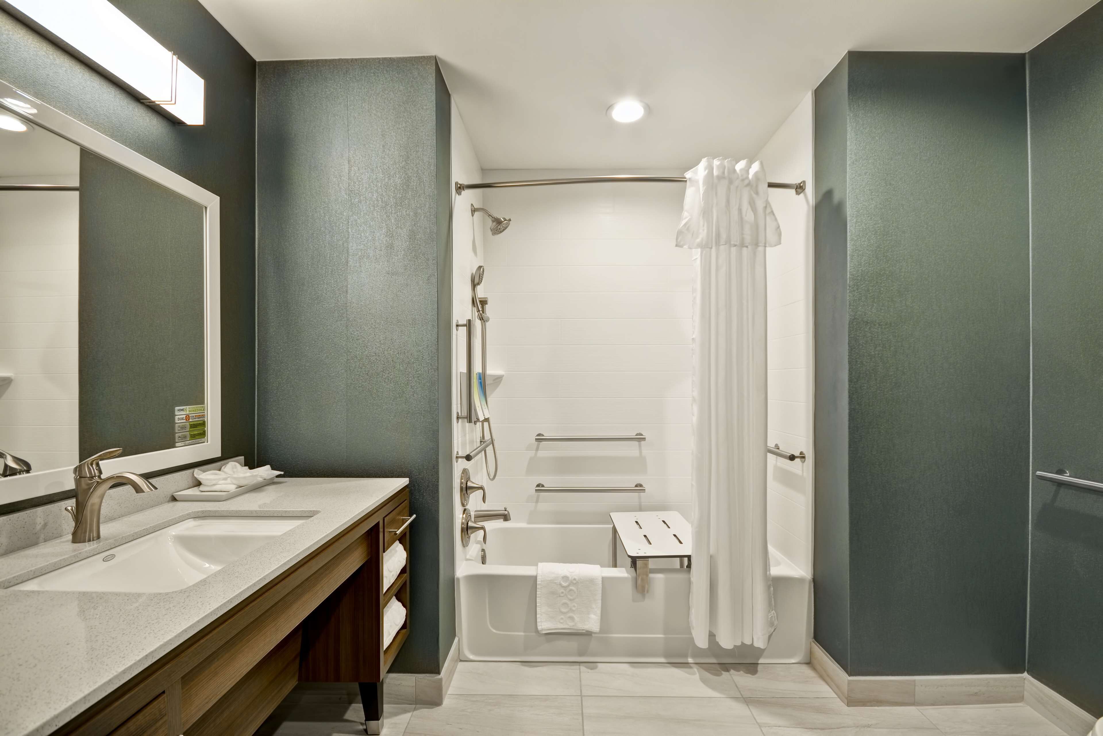 A modern bathroom with a double sink, a bathtub, and a shower area.