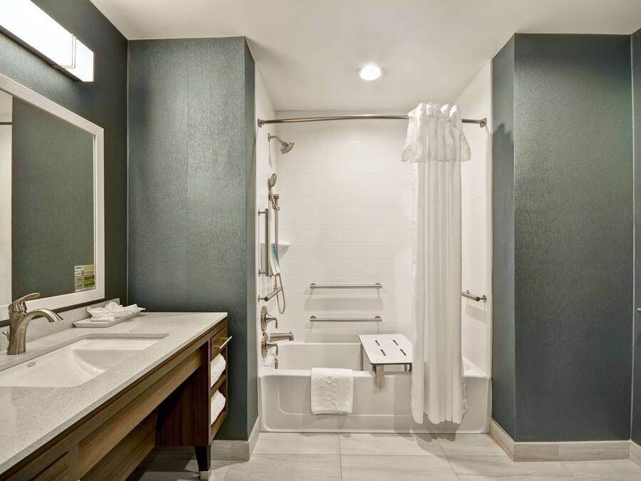 Un baño moderno con lavamanos doble, bañera y zona de ducha.