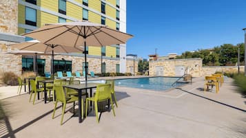 A poolside area with outdoor seating and a pool.