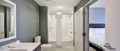 A modern bathroom with a double sink, toilet, and a walk-in shower.