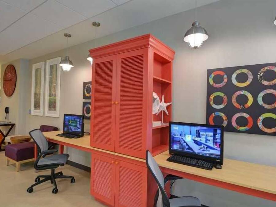 A modern office space with two desks, computers, and office chairs.