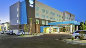 A modern hotel with a prominent logo, a covered entrance, and a parking lot. - Tru by Hilton Sumter (Sumter)