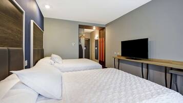 Habitación de hotel con dos camas, un televisor y un espejo.