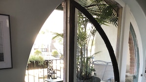 A room with a large arched window leading to an outdoor patio area.