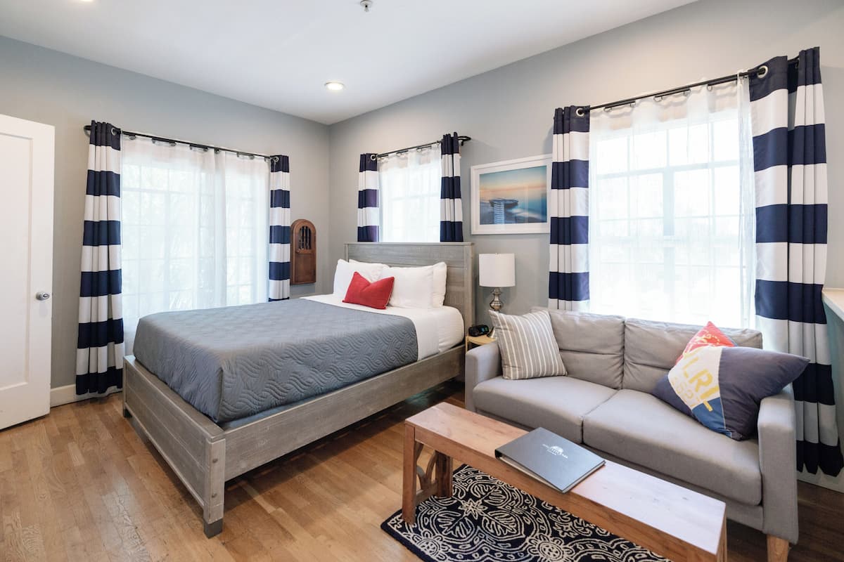 Une chambre à coucher avec un lit, un canapé, une table basse et des rideaux.