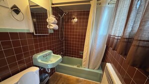 A bathroom with a toilet, sink, and bathtub.
