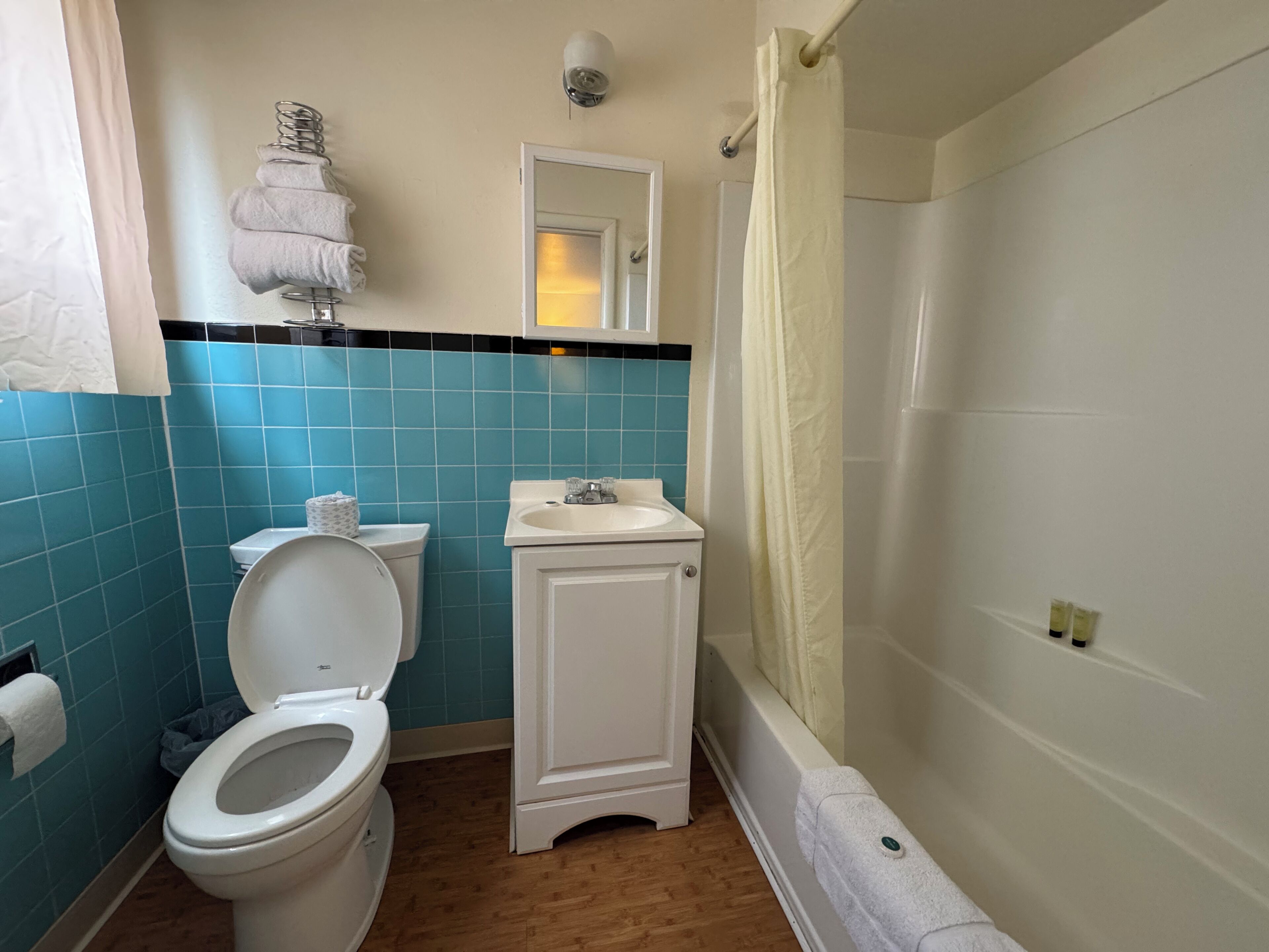 A bathroom with a toilet, sink, and shower.