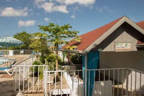 Relax on the beachfront terrace with a refreshing drink at the bar, surrounded by lounge chairs and umbrellas by the pool.