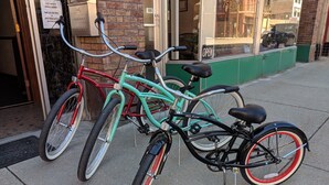 Two bicycles parked on a sidewalk in front of a building. - Ryan Hotel (Wallace)