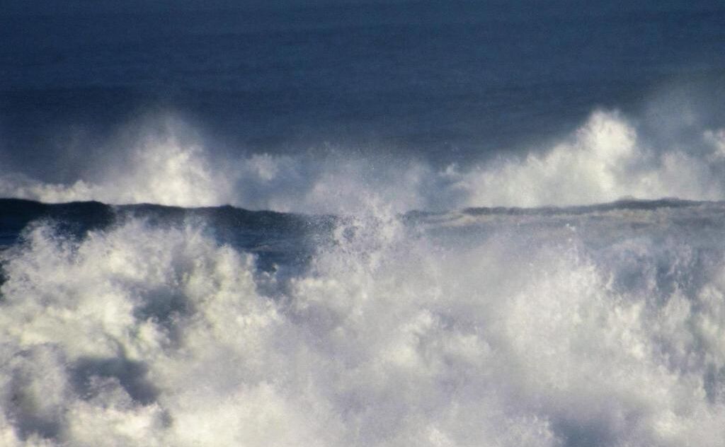 Vista del océano con olas rompiendo en la orilla.
