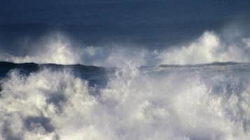 Vista del océano con olas rompiendo en la orilla.