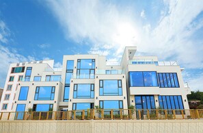A modern multi-story building with large windows and a flat roof. - Poolvilla K (Gangneung)